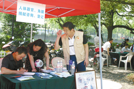 志愿者叶伟棠(右)在广场开展宣传活动(资料照片)