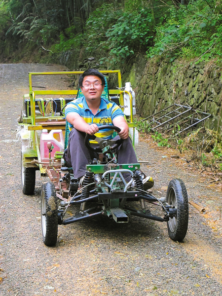 朱振霖驾着他自制的电动车从山上劳作归来. (王量迪 摄)