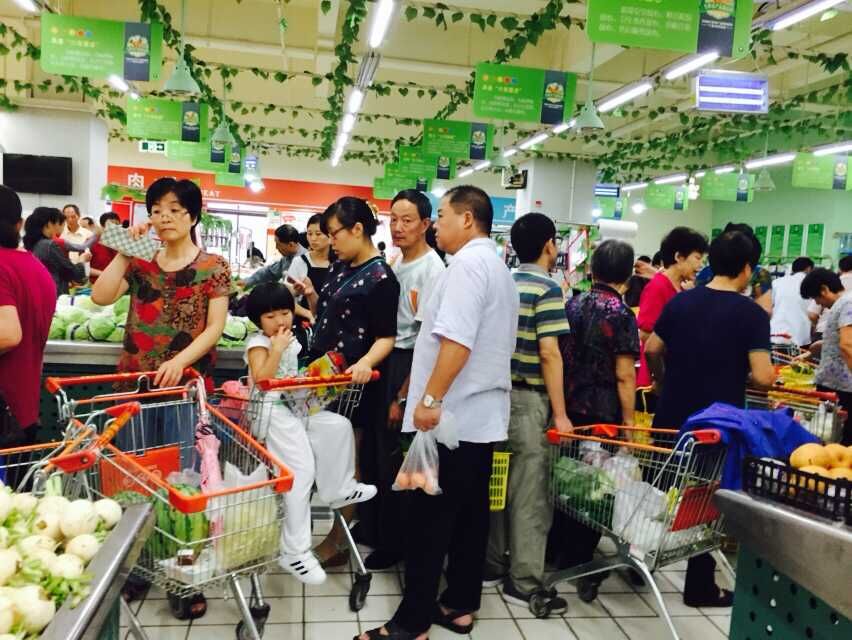 堇山中路三江超市排队称菜的场景